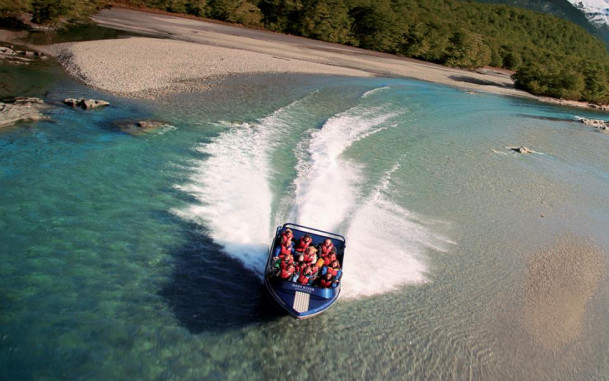 Jet boat speeding along the Dart River in Mount Aspiring National Park