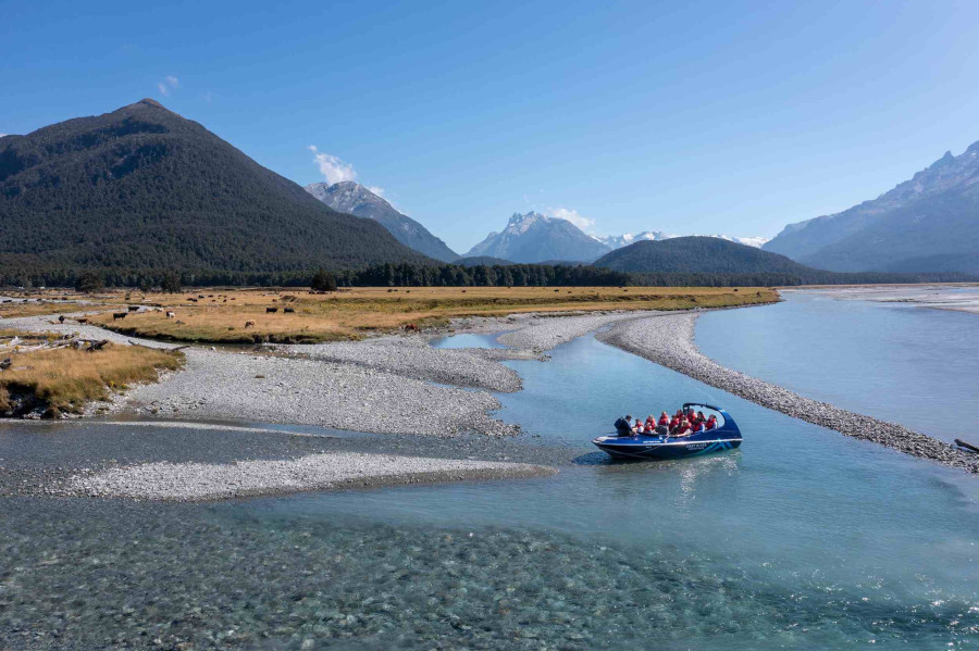 Dart River Adventures jet boat on the Dart River with mountains in the background