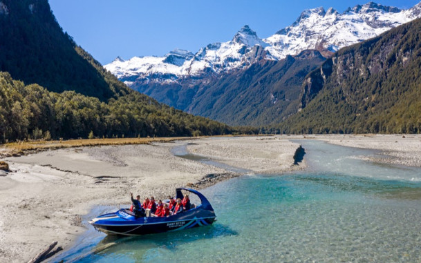 Dart River Adventures jet boat on the Dart River with mountains in the background