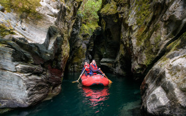 Couple paddling inflatable Funyaks on the Dart River through the hidden chasms