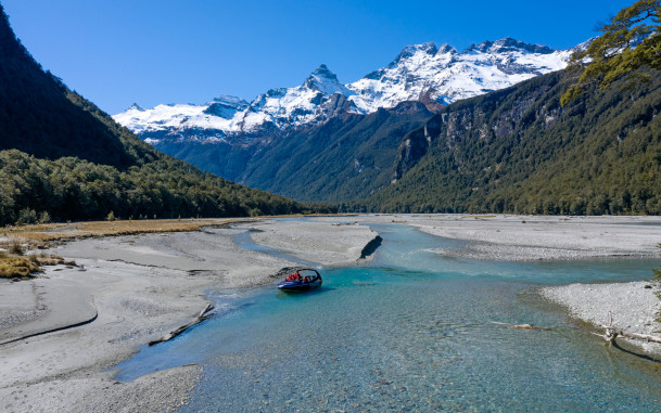 Wilderness Jet boat on the Dart River in Mount Aspiring National Park with mountains in the background